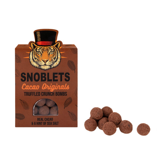 Chocolate truffle "Snoblets Cacao Originals" by Cacao Originals, next to the box with a tiger in a top hat.
