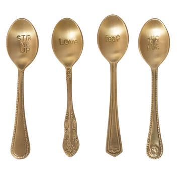 Gold-toned engraved spoons with unique handle designs, each stamped with a different phrase.