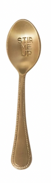 Gold-toned engraved spoon with "Stir Me Up" text, and a textured handle.