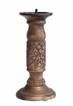 Mango wood candle holder with carved floral pattern detail.