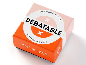 It's Debatable game box with pink and orange coloring, featuring the game title in bold black letters.