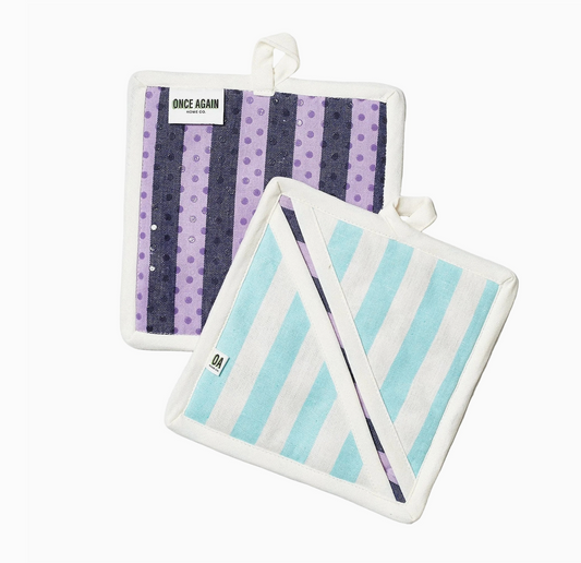 Set of two pot holders by Once Again Home Co., one with purple stripes and polka dots and the other with blue stripes.