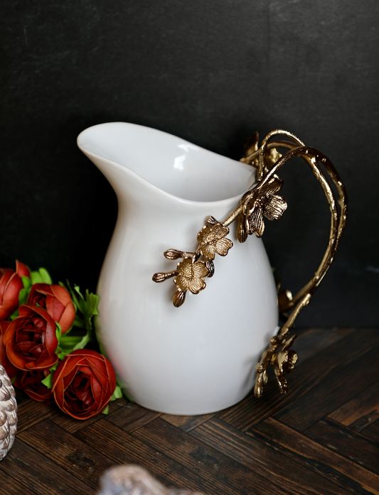 White pitcher with gold handle from The-Little-Shop-Of-Gifts, featuring a decorative floral motif and elegant styling.
