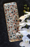 Enameled metal tray with gold rim from unknown vendor, featuring a floral pattern with white orchids.
