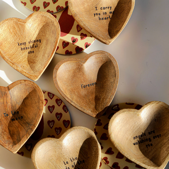 Wood carved trinket trays with various inspirational quotes, with patterned coasters underneath.