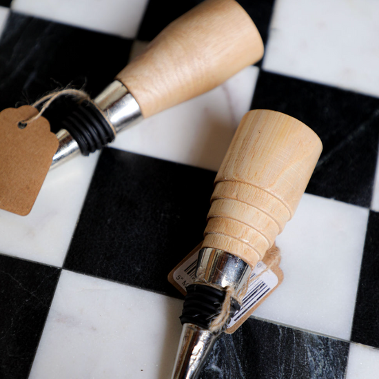 Mango wood stopper by Bloomingville on a checkered surface.