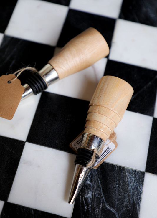 Mango wood stopper by Bloomingville on a checkered surface.