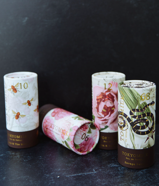 Boxed parfum by TokyoMilk, with floral, bee, and snake art on cylindrical containers.
