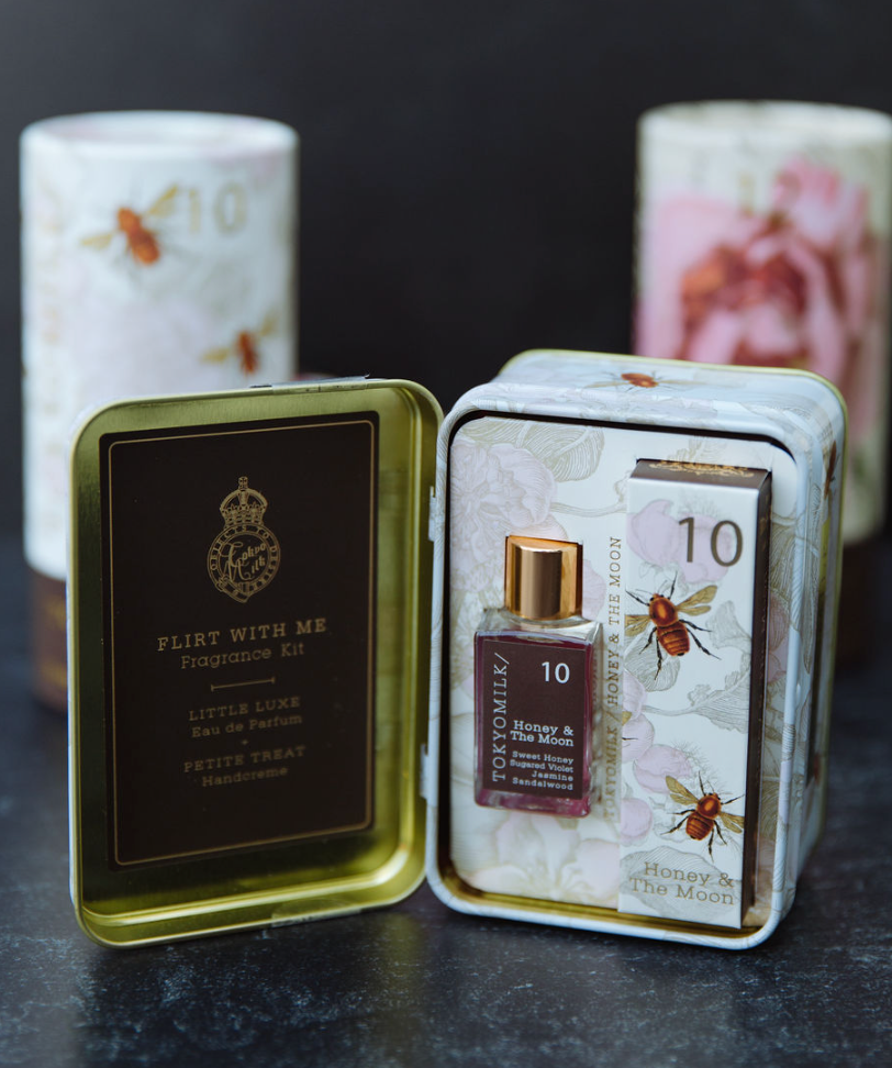 Fragrance kit by TokyoMilk with honey and moon design in a decorative tin container.
