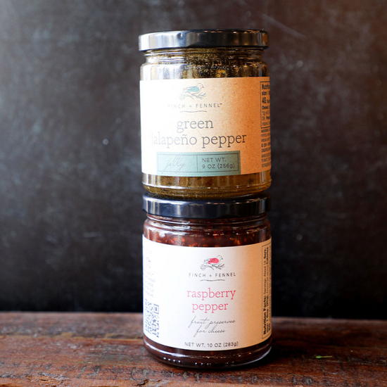 Green jalapeño pepper jelly by Finch and Fennel stacked on raspberry pepper preserves.