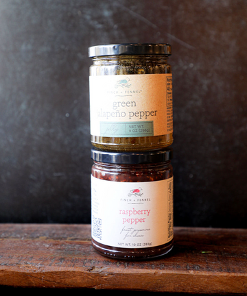 Green jalapeño pepper jelly by Finch and Fennel stacked on raspberry pepper preserves.
