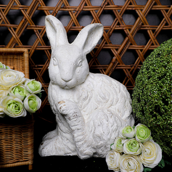 White faux concrete rabbit from Home Decor, surrounded by flowers and greenery.