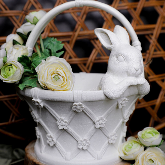 Decorative white rabbit with a basket of flowers on a wooden base against a woven background