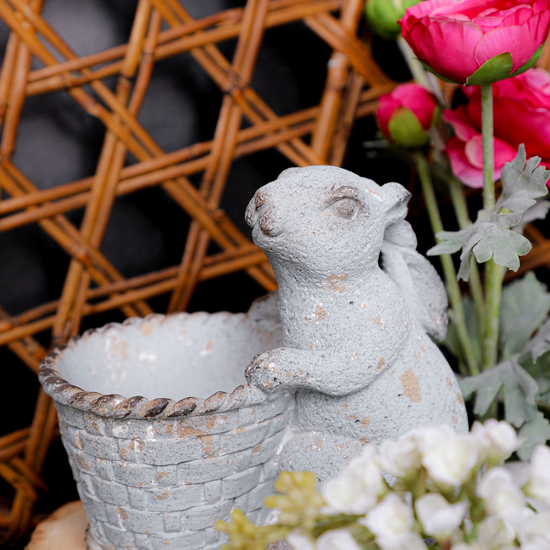 Decorative angel figurine with a crystal bowl on a wooden stand, surrounded by flowers.