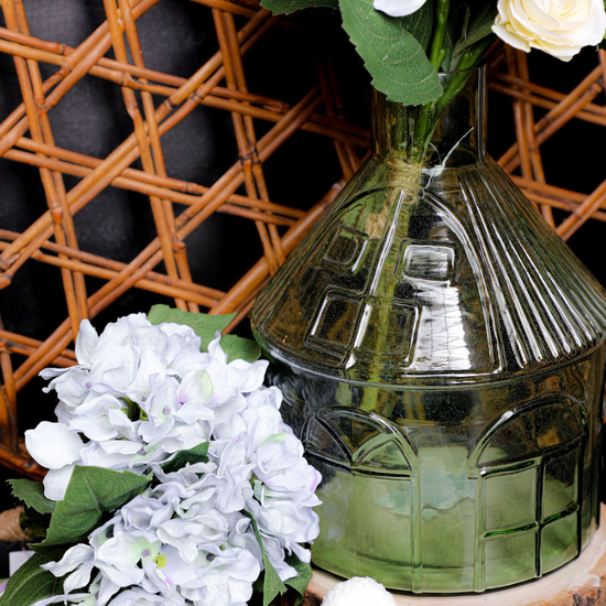 Decorative glass vase with floral arrangement against a woven basket background