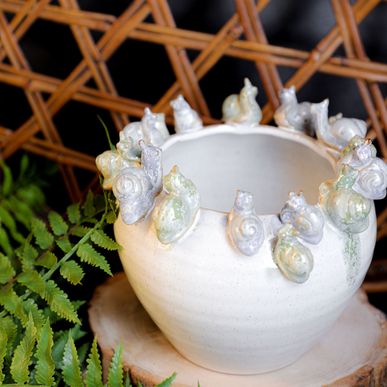 White stoneware planter with snails, featuring a decorative band and textured finish.