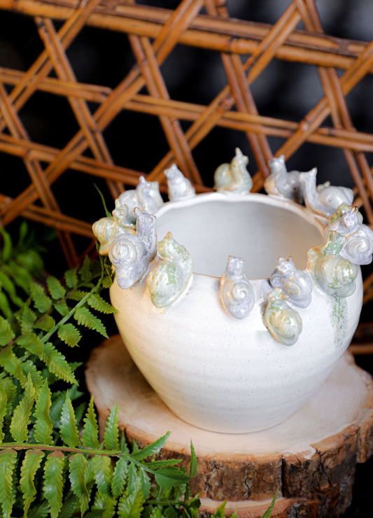 White stoneware planter with snails, featuring a decorative band and textured finish.