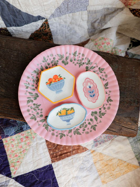 Decorative plate with embroidered designs on a quilted surface