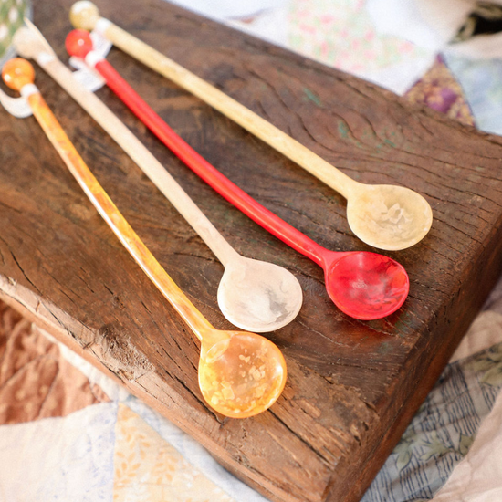 Set of colorful plastic spoons on a wooden surface