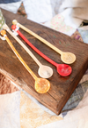 Set of colorful plastic spoons on a wooden surface
