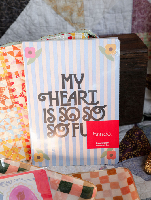 Bando notebook set with colorful designs and text on a textured surface