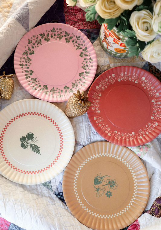 Set of decorative  plates with floral and geometric patterns on a tablecloth.