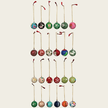 Hand painted paper mache round ornaments, by Karma Gifts, with assorted designs and gold string hangers.
