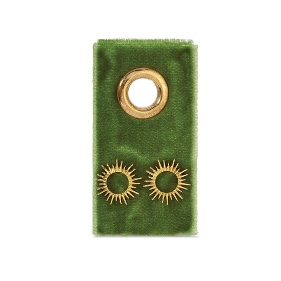 Gold sun stud earrings on green velvet gift tag with gold eyelet.