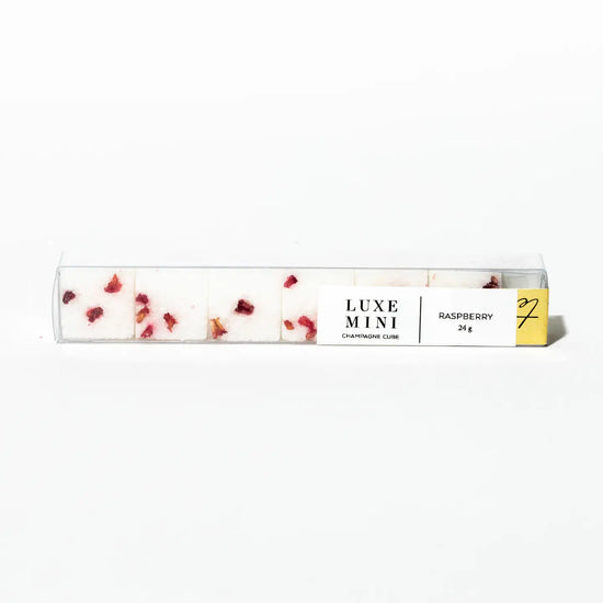 Raspberry champagne cubes by Luxe Mini, in a clear rectangular package with red petal pieces.