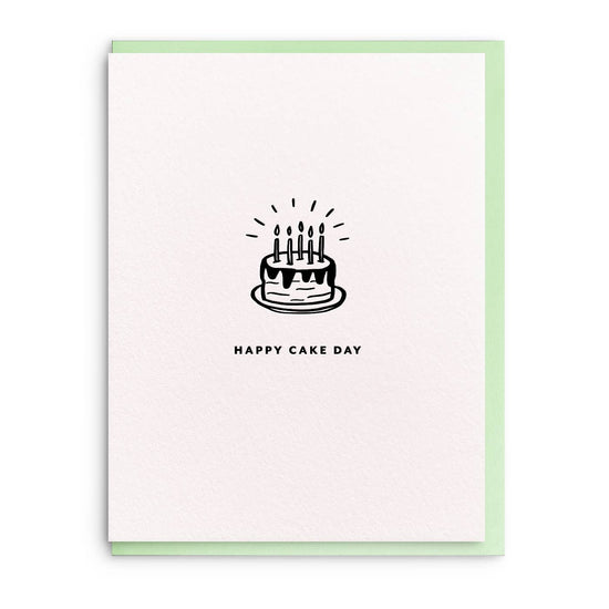 Birthday greeting card with a cake drawing by Smitten on Paper, featuring a simple black-and-white design on textured paper with a pastel green border.
