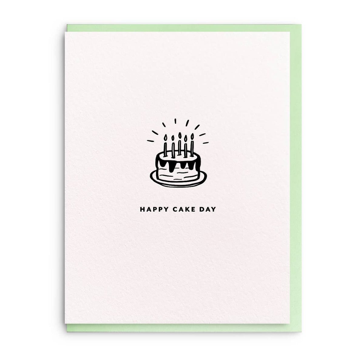 Birthday greeting card with a cake drawing by Smitten on Paper, featuring a simple black-and-white design on textured paper with a pastel green border.
