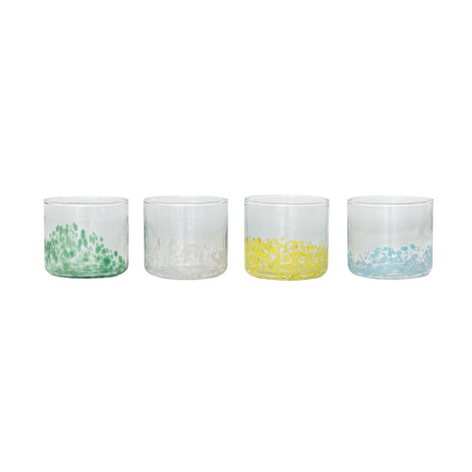 Four small glass containers with colorful patterns on a white background