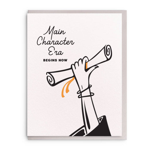 Letterpress graduation greeting card with "Main Character Era" text, by Wild Ink Press, featuring a hand holding a diploma.