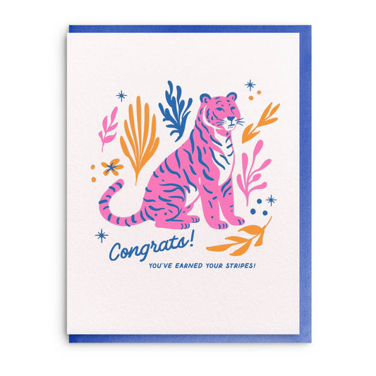 Congratulations card with a pink tiger by Idlewild Co., featuring blue and orange botanical accents.