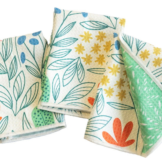 Set of three cream-colored Mighty Mini towels from RJW, patterned with colorful botanical illustrations.
