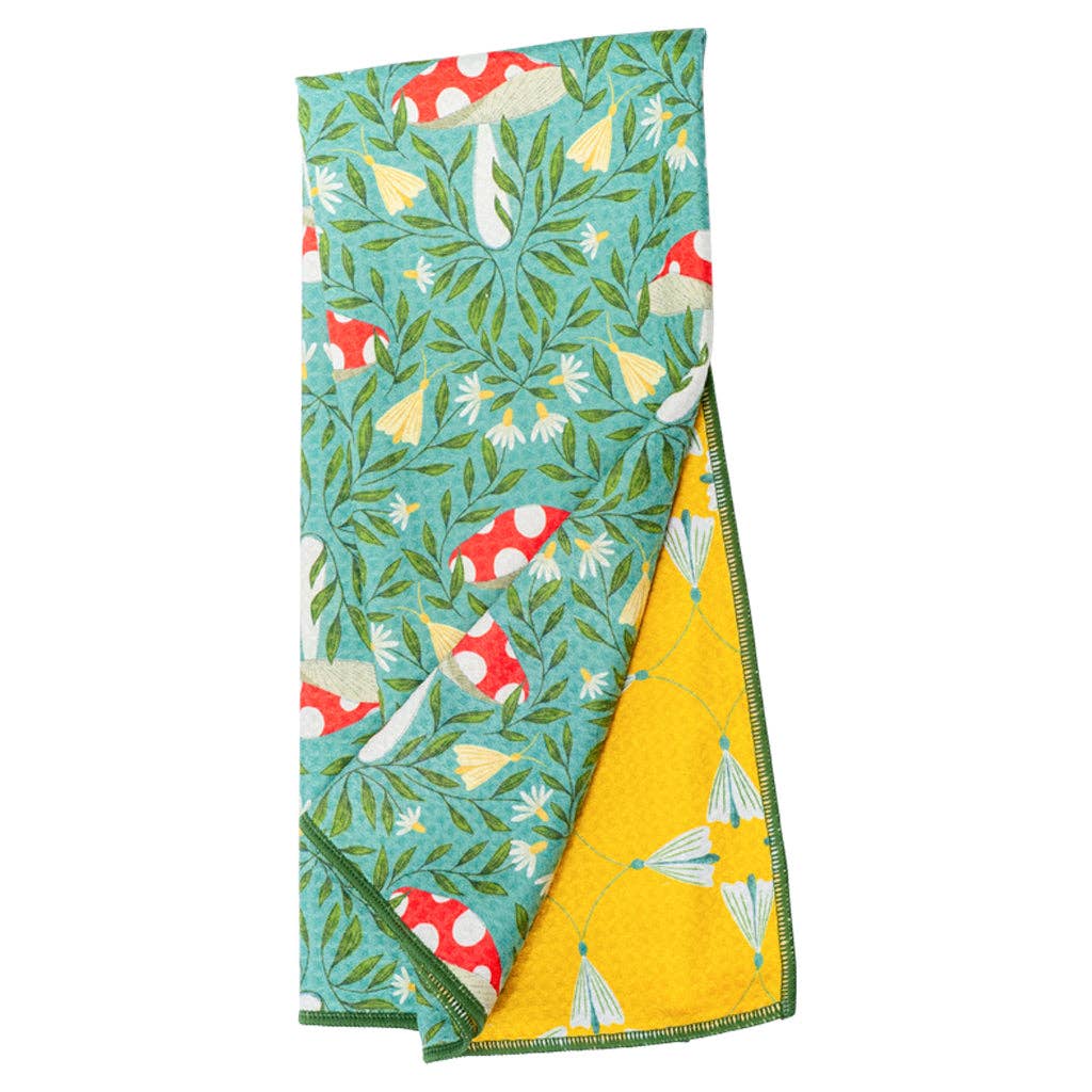 Reversible kitchen towel with Undergrowth Herb pattern by Danica, featuring mushrooms, flowers, and a contrasting yellow side.
