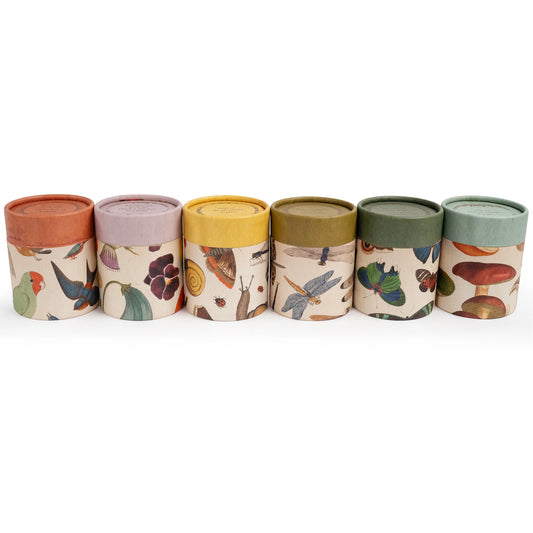 Scented candle by Danica Studio with a flora and fauna pattern.