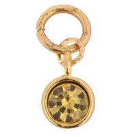 Gold gemstone charm by Anna Beck with a round yellow gem stone in a gold setting.
