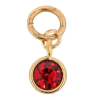 Gold gemstone charm with red stone.
