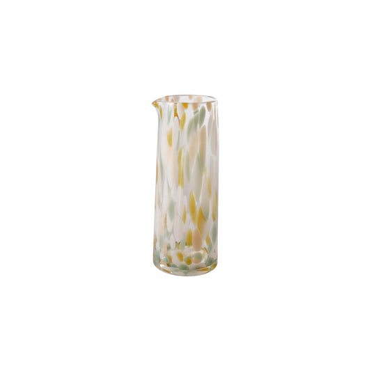 Glass pitcher with yellow and green abstract pattern on a white background
