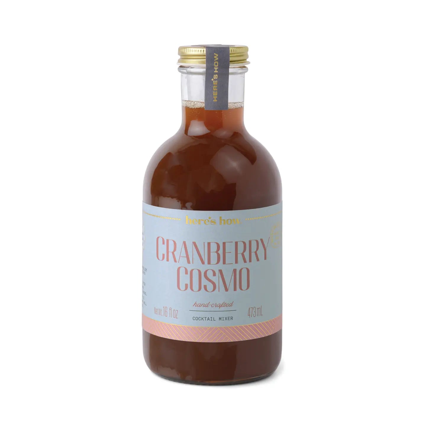 Cranberry cosmo cocktail mixer by Here's How in a clear glass bottle with a gold lid.