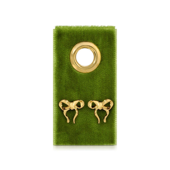 Gold sweet bows on velvet tag by Marni, displayed on textured green velvet.