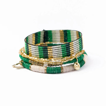 Bracelet stack by Grace & Alex, featuring green, white, and gold beaded layers with a charm.