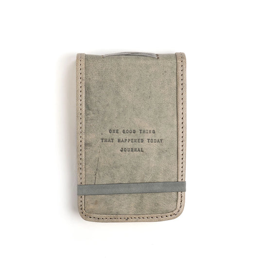 Gray leather journal by Eccolo with an elastic band, decorative stitching, and debossed text.
