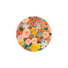 Floral pattern coaster by Seedlings with pink, yellow, and blue flowers on an orange background.