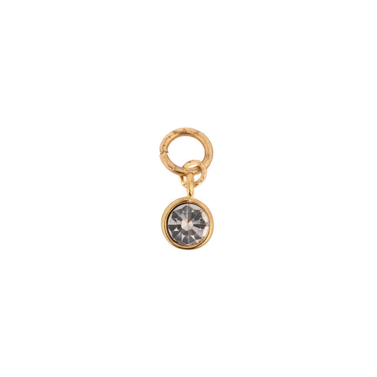 Gold-tone charm with a gemstone by Pilgrim, featuring a clear, faceted crystal.