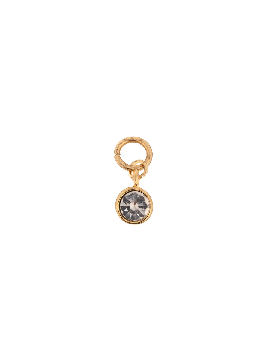Gold-tone charm with a gemstone by Pilgrim, featuring a clear, faceted crystal.