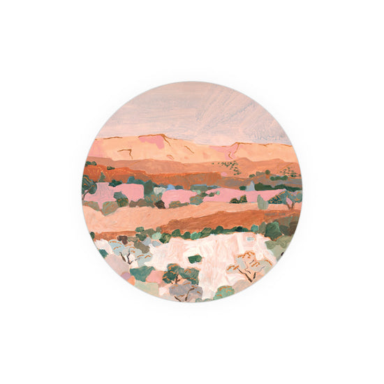 Round art coasters of an arid landscape from Kitchen & Tabletop, featuring muted pink, brown, and green tones.