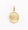 Gold coin charm from Sophie featuring a compass rose design.
