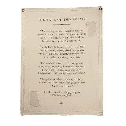 Canvas wall hanging with "Tale of Two Wolves" text, from an unknown source, featuring distressed edges and metal grommets.
